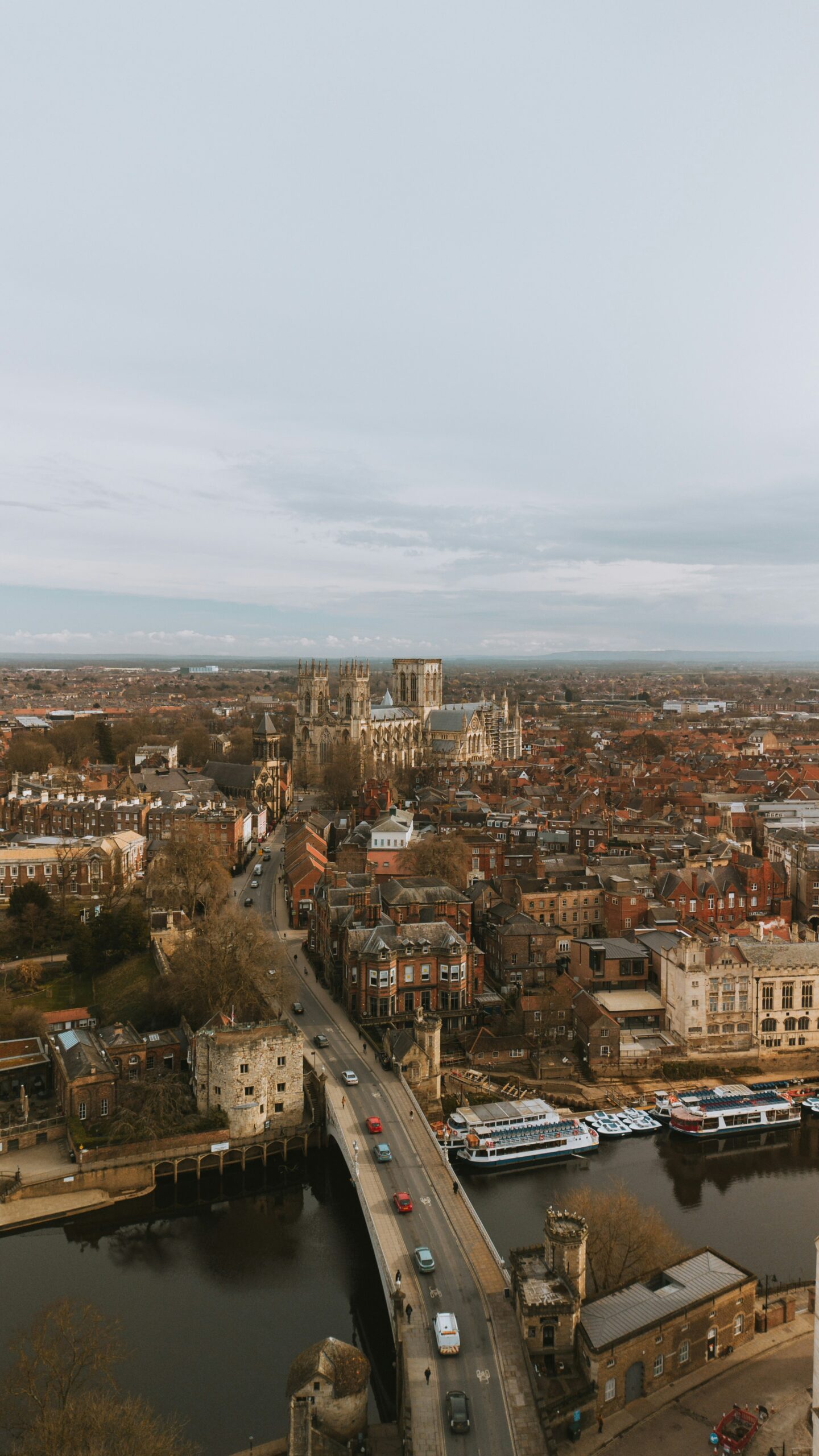 Aerial view of York, UK, showcasing the historic city with its medieval streets, the iconic York Minster Cathedral dominating the skyline, and the River Ouse winding through the city.